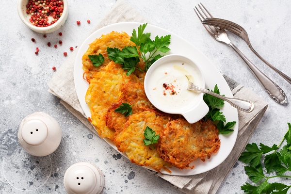 draniki potatof ritters vegetarian potato pancakes served with fresh herbs and garlic yogurt sauce top view - Драники с пряностями