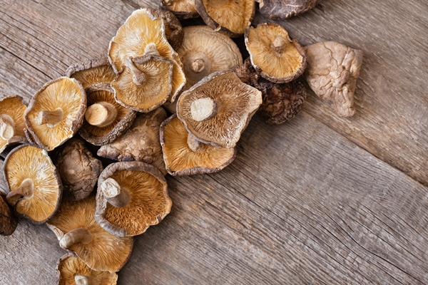 dried shiitake mushrooms on a wooden background - Рисовый суп с грибами