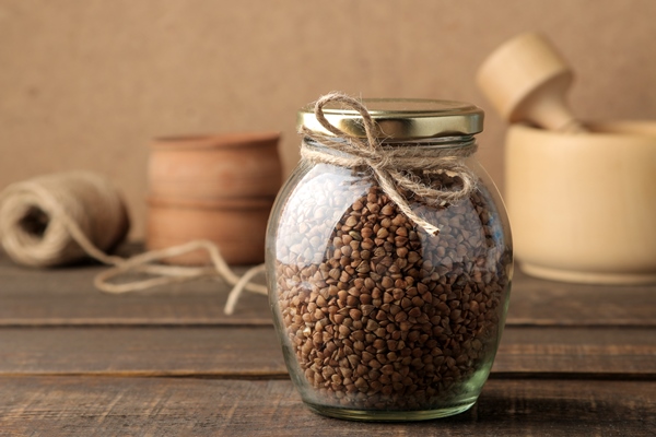 dry buckwheat groats in a glass jar in the foreground on a wooden brown table cereals healthy food porridge - Кислые щи из свежей капусты (старинный рецепт)