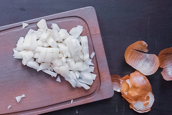 flat lay step by step dicing yellow onion on a wood cutting board - Драники с шампиньонами