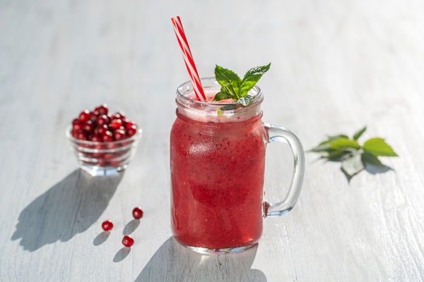 fresh organic red smoothie in glass mug on white table close up refreshing summer fruit drink the concept of healthy eating cranberry and raspberry smoothie in sunny day - Суздальский квас
