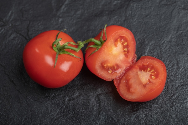 fresh organic tomatoes whole or half cut tomatoes on black background - Щи по-крестьянски