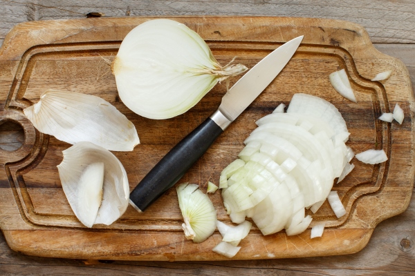 fresh raw white onion sliced on the cooking board - Щи с грибами
