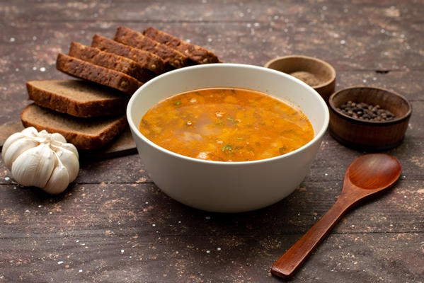 front view orange vegetable soup with bread loafs and garlic on brown food meal soup bread - Суп из сладкого перца с капустой