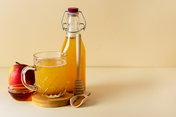 glass mug of fresh organic apple cider with honey and cinnamon yellow background horizontal - Фруктово-ягодный квас