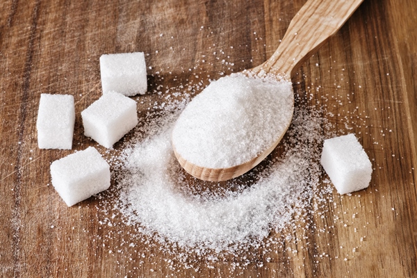 granulated sugar in wooden spoon and sugar cubes on wooden background - Алёнин квас на отрубях