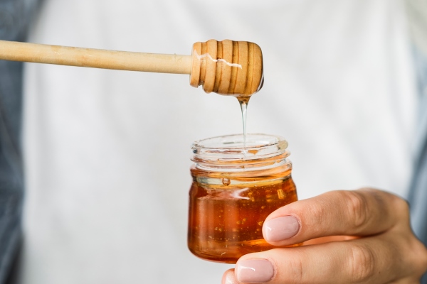 hand holding sweet honey jar - Яблочный суп