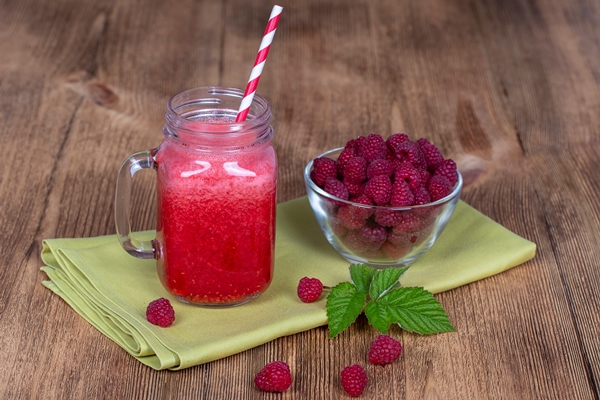 healthy raspberry smoothie on wooden table with green leaves - Малиновый медовый квас