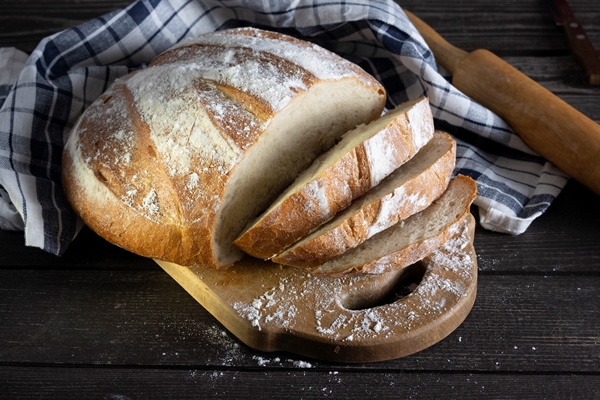 homemade rustic bread sliced with a napkin on a dark wooden plate - Домашний хлеб на сухих дрожжах