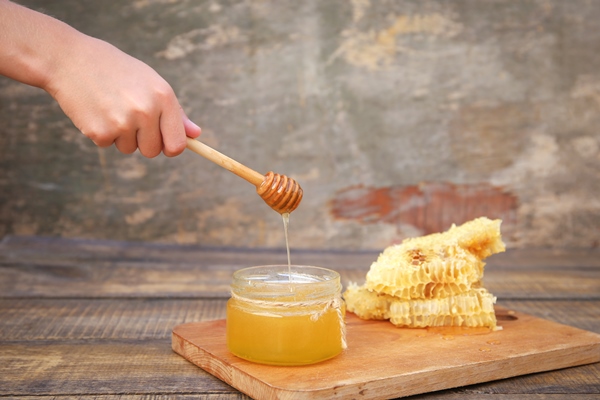 honey in a jar and honeycomb on an old wooden background - Сочиво из риса с корицей