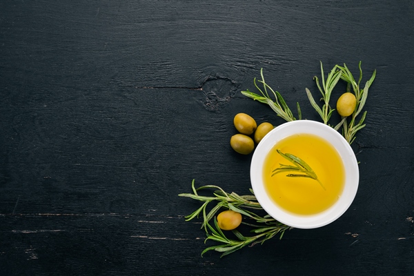 olive oil in a plate and rosemary on a black wooden background free space for - Чиабатта