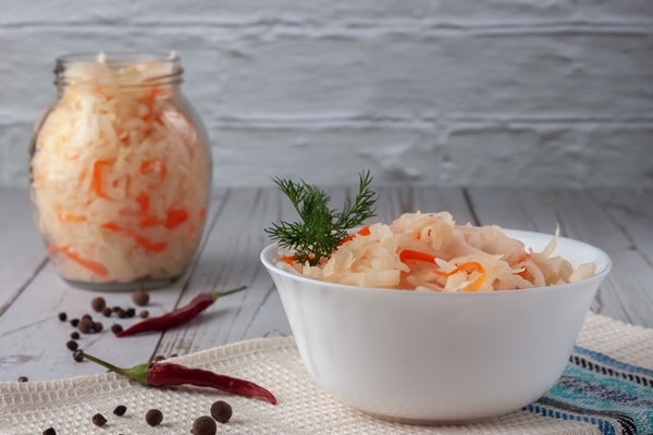 on a wooden table sauerkraut with carrots and spices in a bowl horizontal top view rustic style - Щи с грибами