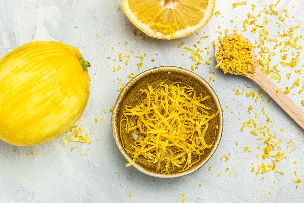 peeling lemon rind to add zest to mediterranean recipes grater peel and lemon zest on light background top view - Ярославский квас