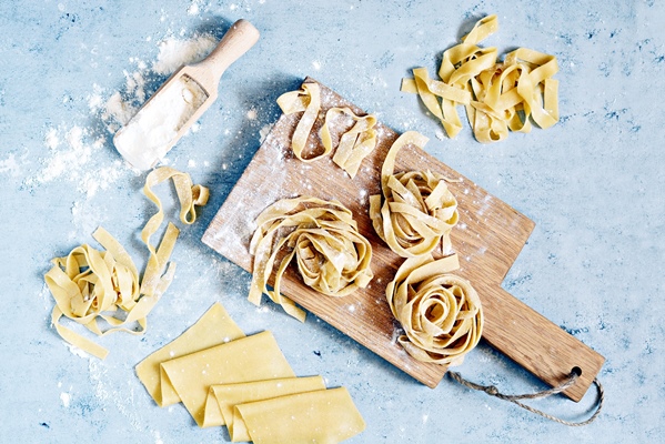 raw yellow italian pasta pappardelle fettuccine or tagliatelle close up egg homemade noodles cooking process long rolled macaroni uncooked spaghetti 1 - Лапша для супа, постный стол