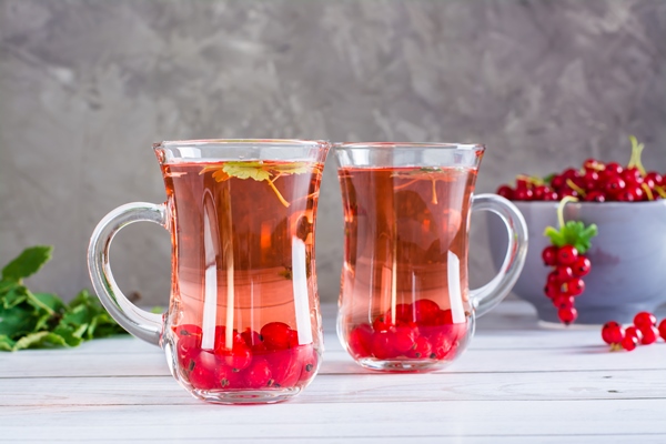 red currant compote in cups on the table homemade summer drinks - Розовый квас