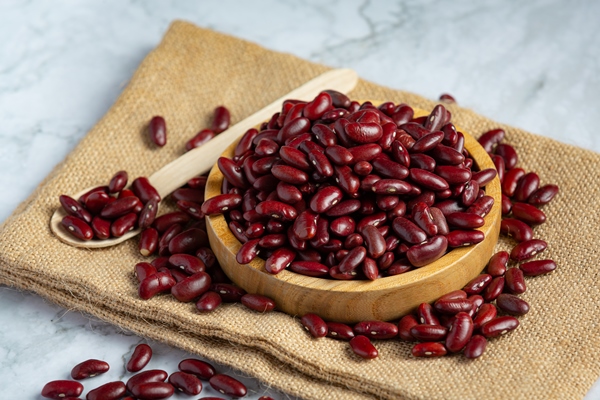 red kidney beans in a small wooden plate place on sack fabric - Постный суп из крапивы и бобовых