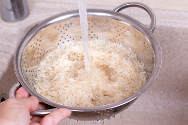 rice in a colander in a kitchen sink cooking in the kitchen - Кутья из риса с орехами и сухофруктами