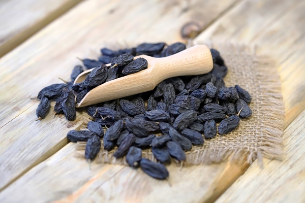 selective focus large blue raisins in a wooden spatula - Сочиво