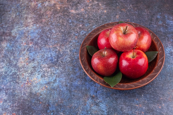 shiny red apples with green leaves on stone background - Яблочный суп