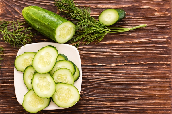 sliced cucumber and dill on a wooden table top view - Окрошка из разностей