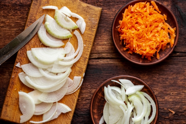 sliced onions and carrots on a dark wooden background ingredients preparation for cooking - Суп картофельный с горохом
