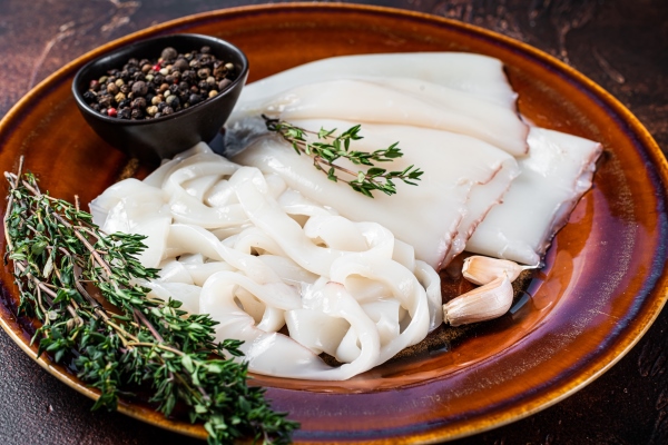 sliced raw rings calamari in a rustic plate with rosemary - Борщ с кальмаром