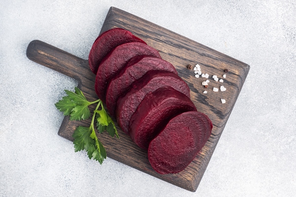 slices of boiled beetroot on a cutting board with parsley leaves on a wooden rustic background copy space - Грибная окрошка, постный стол
