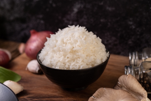 steamed rice in a bowl with garlic and red onion on a wooden cutting board - Рисовый суп с грибами