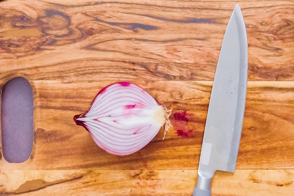 step by step slicing purple onion on a wood cutting board - Драники с пряностями