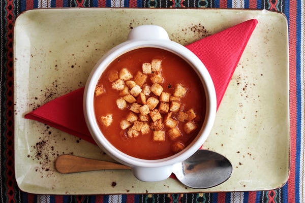 tasty fresh tomato soup with croutons in white ceramic bowl with spoon on a table - Суп-пюре из помидоров с перловой крупой