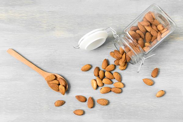 top view of almonds in jar with spoons - Сочиво рисовое с миндалём и миндальным молоком