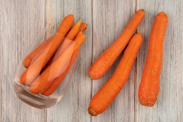 top view of fresh orange carrots on a glass with carrots isolated on a grey wooden background - Солянка овощная