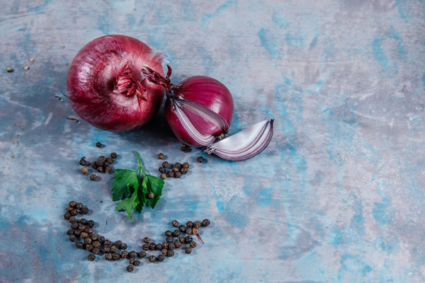 top view red onions with black pepper leaves on textured surface horizontal - Деруны с чесноком