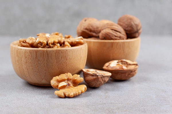 two bowls of whole and cracked walnuts on marble background high quality photo - Сочиво из перловки в термосе
