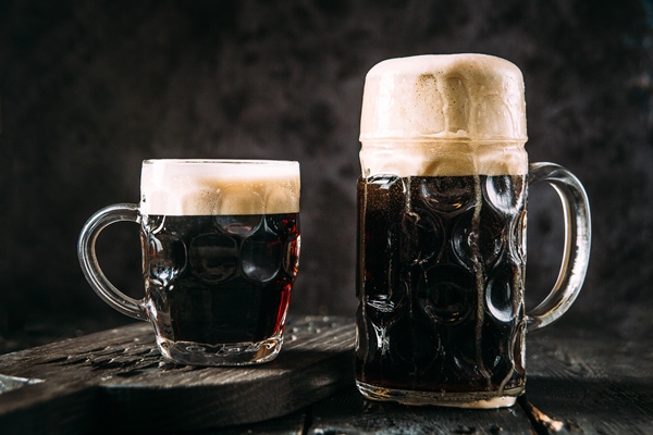 two glass mugs with dark beer on black - Квас из концентрата с сахаром