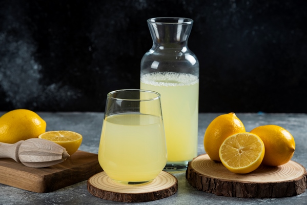 a cup of lemon juice on wooden board - Яблочные цукаты