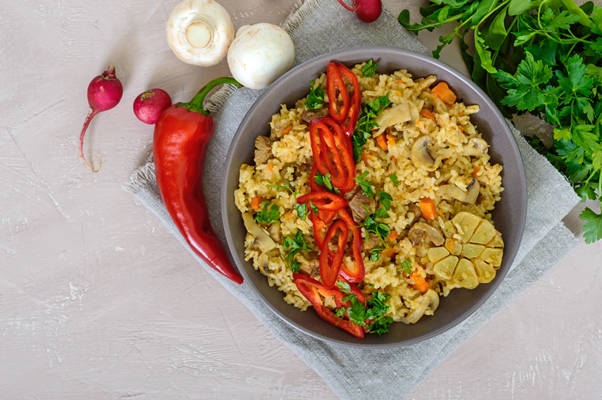 a traditional asian dish pilaf with meat mushrooms and pepper capi in a bowl - Рис с капустой и грибами