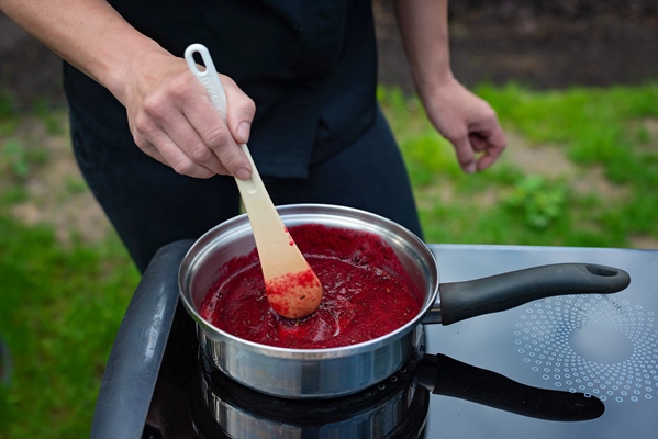 chef cooks berry puree for making marmalade the process of making berry jam - Взбитая манная каша с чёрной смородиной