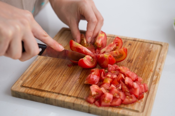 close up of woman cutting tomatoes with knife - Постный соус чатни из яблок