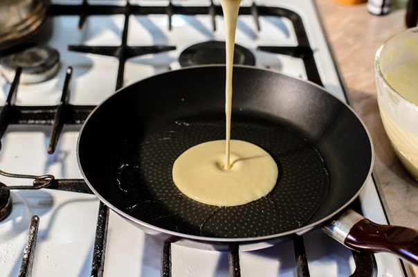 close up on cooking pancakes in pan - Блинчики с рыбой и маринованными огурцами