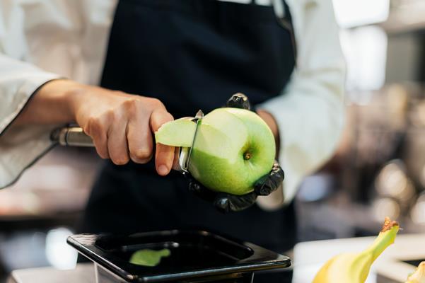 female chef with glove and apron removing apple skin - Яблочный конфитюр