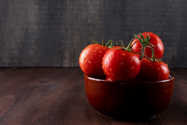 fresh and health tomatoes in ceramic bowl on brown stone surface - Постная аджика острая