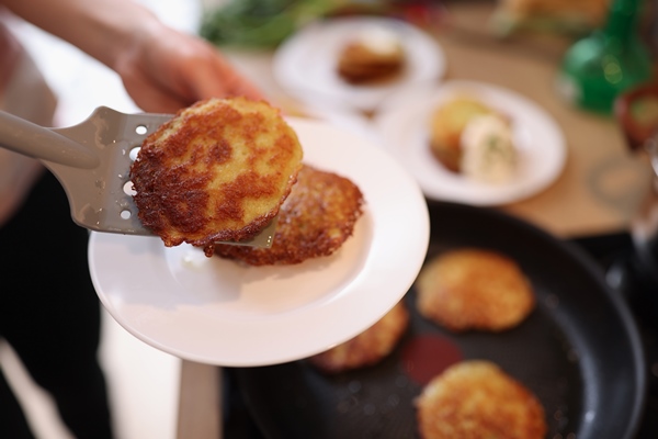 fresh cooking potato pancakes in skillet vegetarian food concept - Картофельники