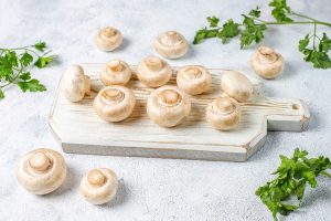 fresh organic white mushrooms champignon top view - Постная рыбная кулебяка