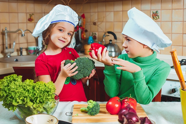 happy family funny kids are preparing the a fresh vegetable salad in the kitchen - Учим детей готовить