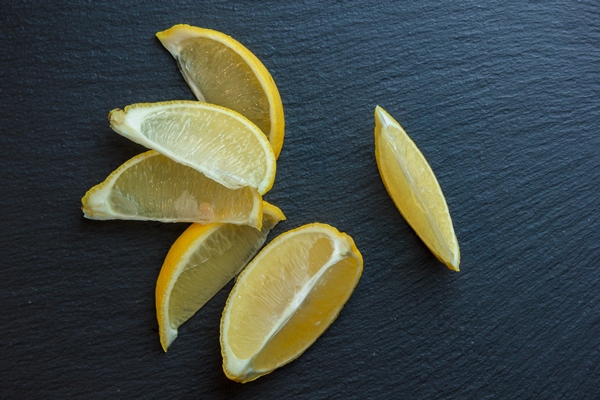 lemon slices on a dark stone surface top view copy space for - Сбитень с корицей, имбирем и лимоном
