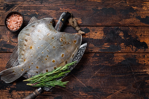 raw plaice flatfish fish on butcher board with knife dark wooden background top view copy space - Учим детей готовить отварную рыбу
