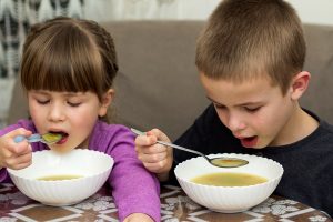 two children boy and girl eating soup - Правила составления меню