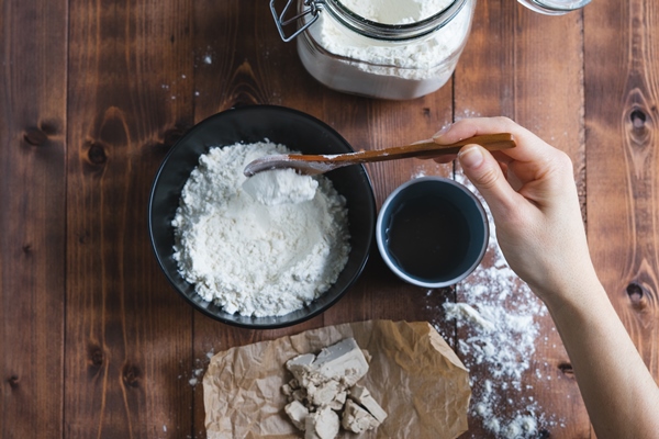 a woman s hand mixing sourdough with a wooden spoon bakery concept 1 - Лобиани