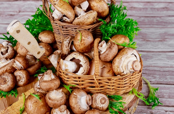 brown portobello mushrooms in wicker wooden basket with grass decoration - Постные фаршированные шампиньоны